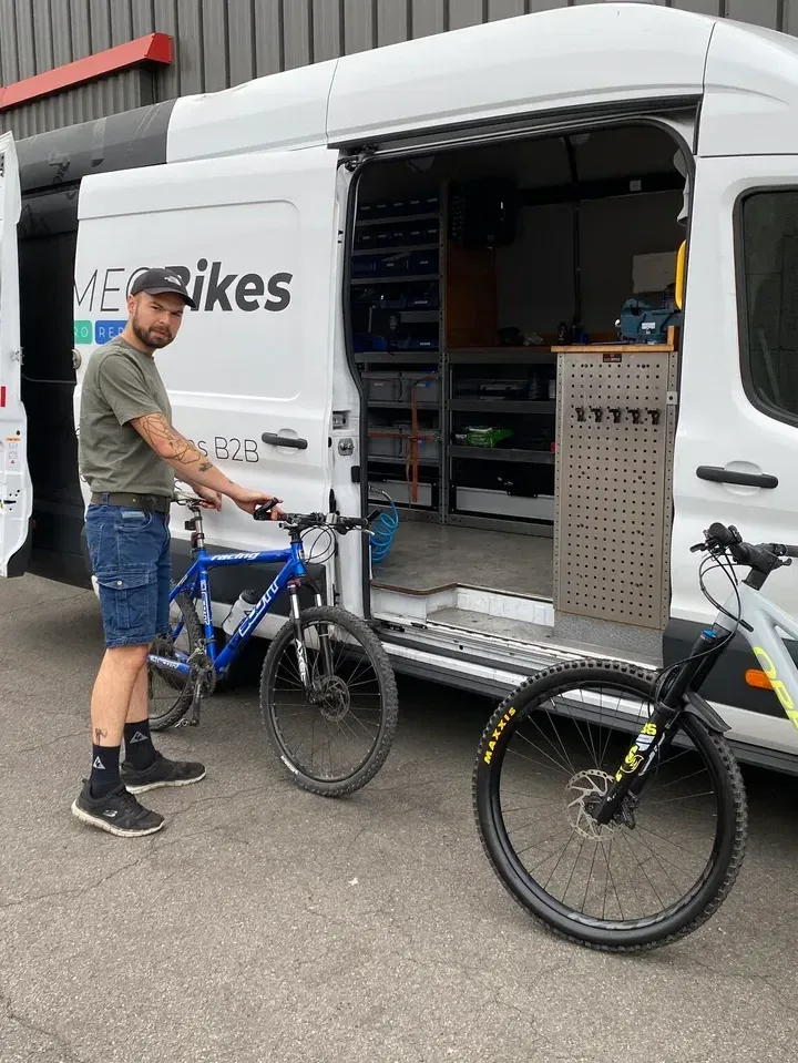 Un technicien KAMEO Bikes à côté d'une camionnette-atelier équipée
